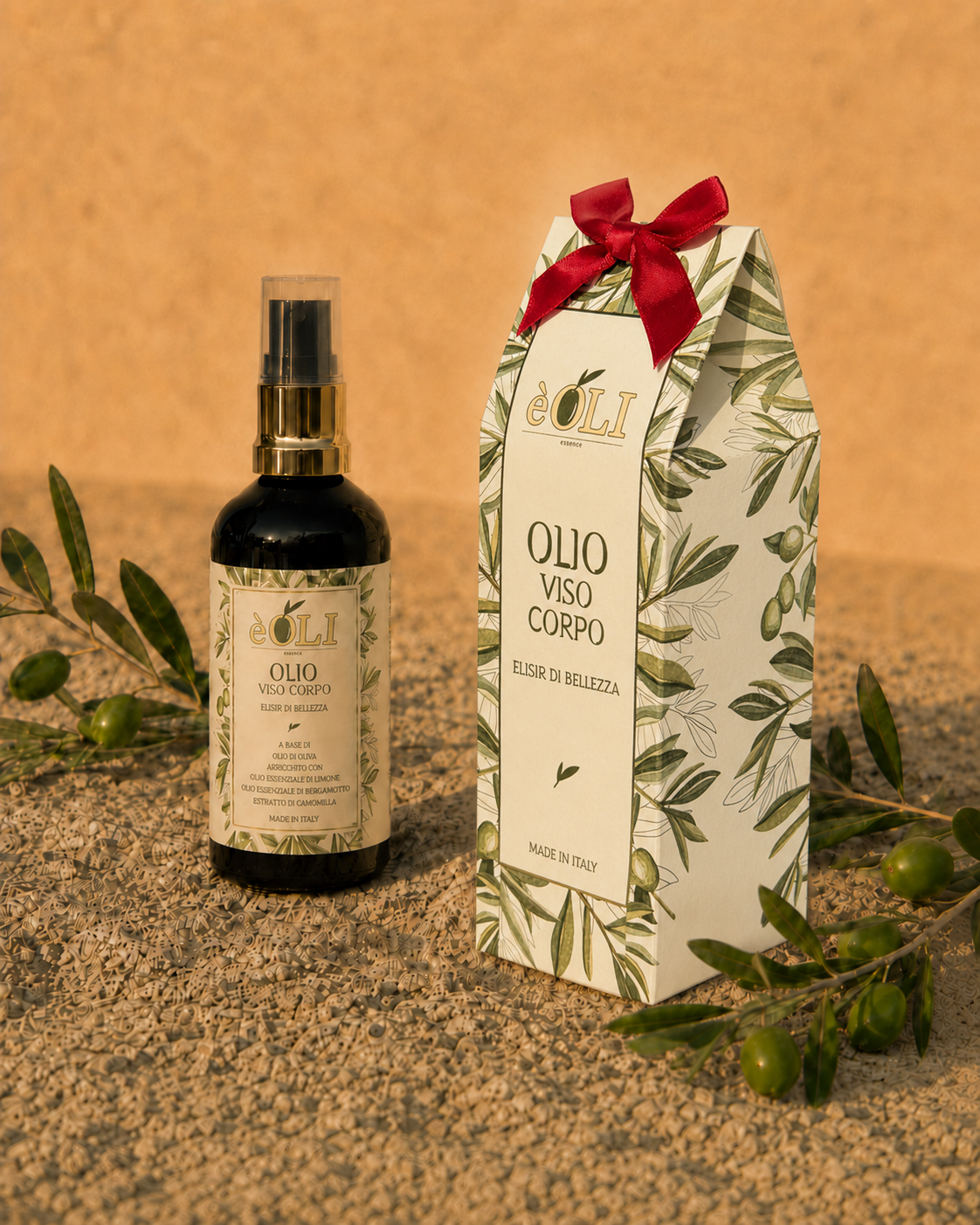 Flacone èOLI e packaging su sabbia con rami di olivo